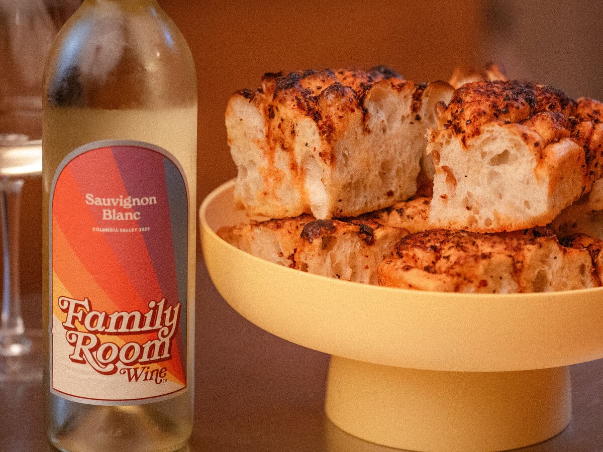A bottle of Family Room Sauvignon Blanc beside a bowl of focaccia
